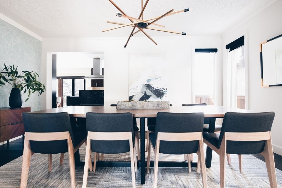 Mid-century modern dining room with gray cloth chairs and gold light fixture